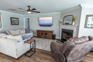 Living room featuring ceiling fan, crown molding, 