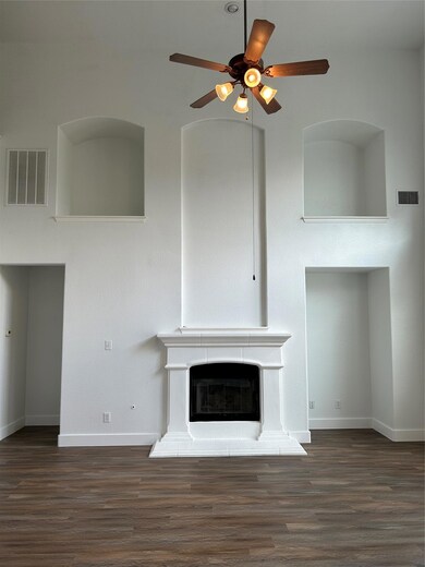 Unfurnished living room featuring a ceiling fan, 