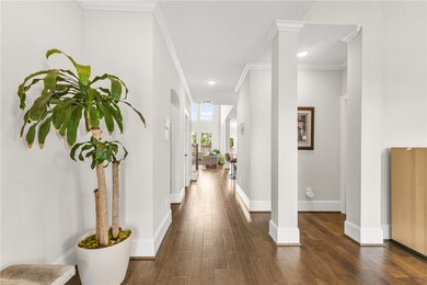Corridor with dark wood-type flooring, crown molding, and recessed lighting