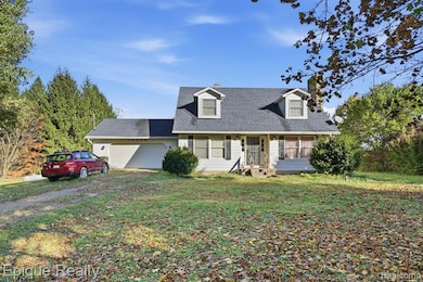 New england style home with a chimney, a front lawn, a shingled roof, a garage, and driveway
