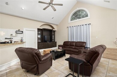 Living room with high vaulted ceiling, ceiling fan, and light tile floors