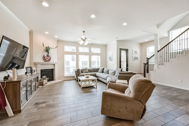 Living room open to the kitchen features a fire pl