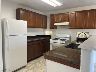 Kitchen featuring under cabinet range hood, dark s