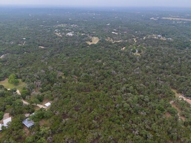 View of property location with a heavily wooded a