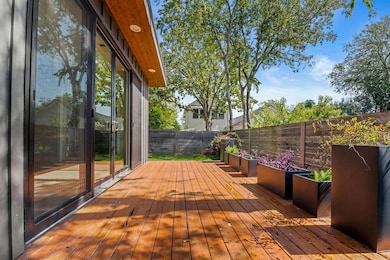 Wooden terrace with a fenced backyard