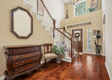 This charming two-story brick home features a well-maintained front yard with mature trees and landscaping. It has a double garage and a welcoming entrance, perfect for families seeking a comfortable and inviting residence.