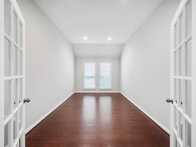 Alternative view of the study showcasing the rich, dark wood flooring.