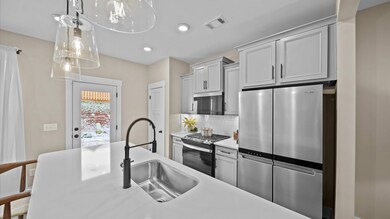 Kitchen with gray cabinetry and large island for counterstools