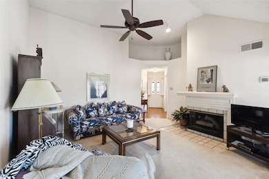 Living room with ceiling fan, high vaulted ceiling