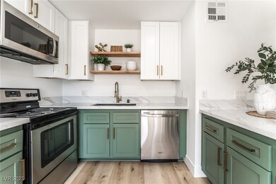 Kitchen with white cabinets, stainless steel appli