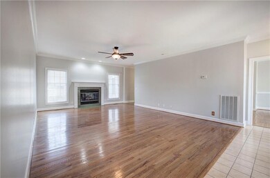 Unfurnished living room featuring a wealth of natural light, visible vents, light wood-style floors, and ceiling fan