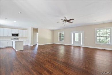 Unfurnished living room featuring ceiling fan and dark hardwood / wood-style floors