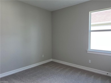 Carpeted empty room with baseboards