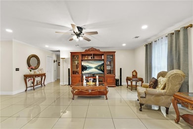 Living room with recessed lighting, ceiling fan, light tile floors, and ornamental molding