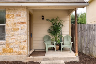 Property entrance with a shingled roof, fence, an