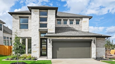 View of front of property with stone siding, driveway, and a garage