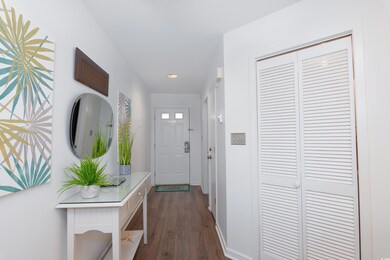 Hall with dark hardwood / wood-style floors