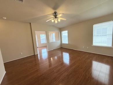 Spare room with a ceiling fan, dark wood-style flo