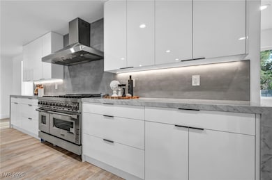Kitchen with wall chimney range hood, double oven