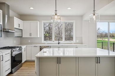Kitchen boasts quartz countertops & a spacious island, perfect for both meal prep and casual gatherings. Photos are from previous, similar model. The options, features and color scheme will vary