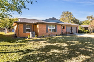 Single story home featuring brick siding, concrete driveway, an attached garage, and roof with shingles