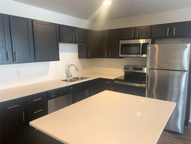Kitchen with a kitchen island, appliances with sta