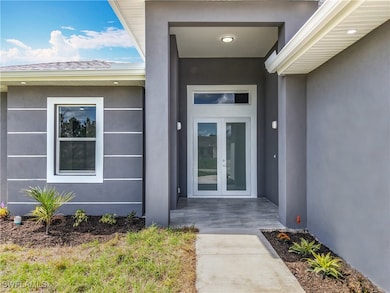 View of exterior entry with french doors and stucc
