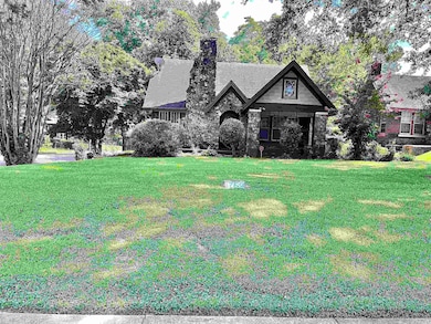 View of front of home featuring a front yard, a chimney, and stone siding