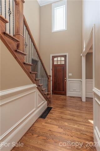 2 Story entrance foyer with tall wood front door.