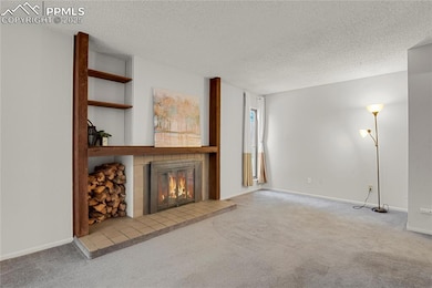 living room featuring carpet, a tile fireplace