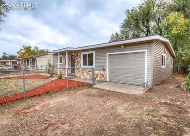 View of front facade with stone siding, a garage, and driveway