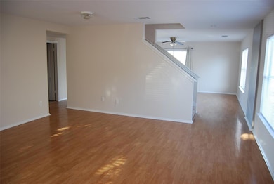 Unfurnished living room with visible vents, baseb