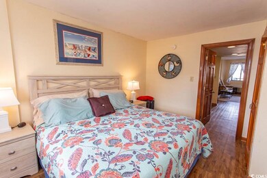 Bedroom with dark hardwood / wood-style flooring