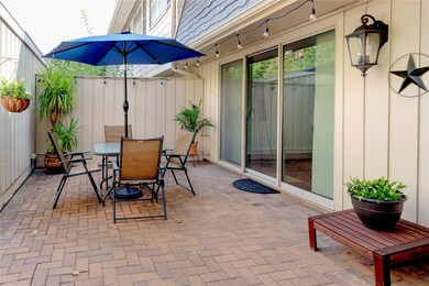 This cozy patio features a brick floor, a seating area perfect for outdoor relaxation. Sliding glass doors provide easy access to the interior, and decorative elements add charm.