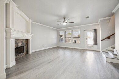 Unfurnished living room featuring stairway, a high end fireplace, crown molding, ceiling fan, and light wood-type flooring