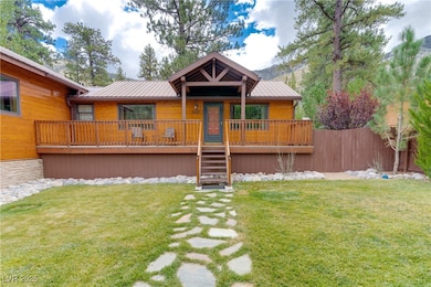 View of front of property featuring a front lawn, stairs, a metal roof, and a deck with mountain view
