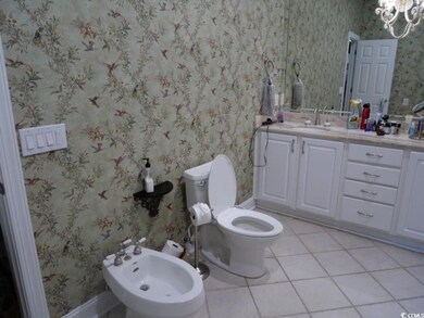 Bathroom featuring a bidet, vanity, tile patterned floors, a chandelier, and wallpapered walls
