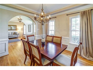 Formal dining room has pretty iron chandelier with