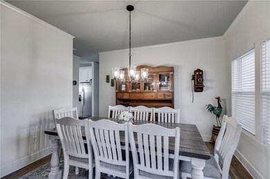 Dining area with crown molding, dark wood-type flo