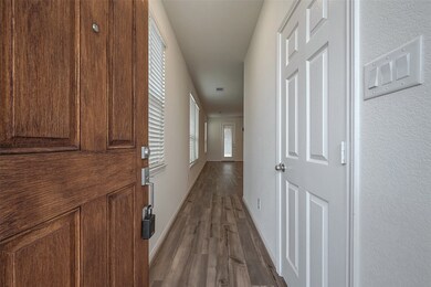 Inviting entrance features a warm wood door and a bright, airy hallway, setting the perfect tone for the rest of the house.