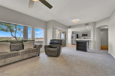 Living area with visible vents, a ceiling fan, lig