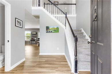 Foyer entrance with light wood-type flooring, base