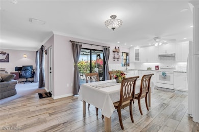 Dining space featuring a desk, crown molding, ligh