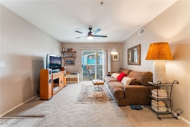 Carpeted living area with a ceiling fan and basebo