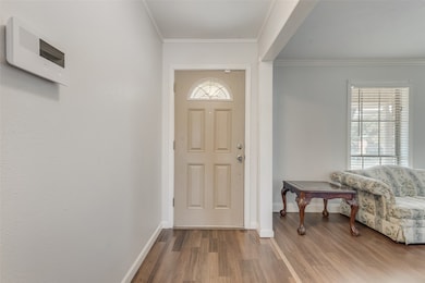 Entryway featuring wood finished floors and ornamental molding