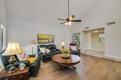 Living room with high vaulted ceiling, wood finished floors, and ceiling fan