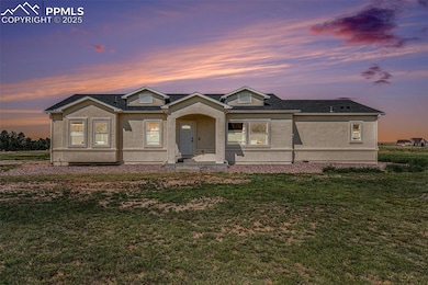 View of front of property featuring stucco siding, a front lawn, and a shingled roof
