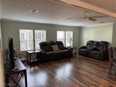 Living area featuring ceiling fan, crown molding,