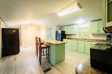 Kitchen featuring green cabinetry, black applianc