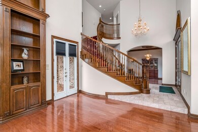 Foyer Entrance featuring an inviting chandelier, curved stairway and open to Formal Rooms